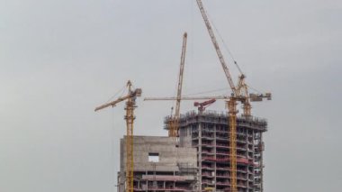 İnşaat halindeki bir gökdelenin havadan görünüşü Dubai marinasında büyük vinçler zamanlanmış..