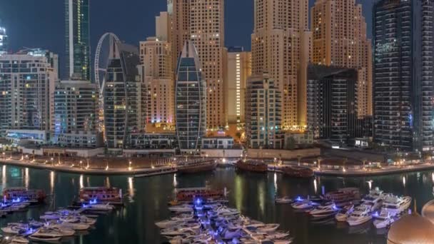 Yachts de luxe garés sur la jetée dans la baie de Dubai Marina avec vue aérienne de la ville nuit au jour le jour timelapse — Video