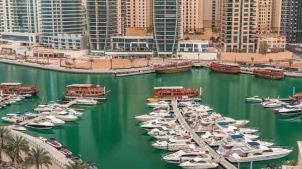 Yachts de luxe stationnés sur la jetée dans la baie de Dubai Marina avec vue aérienne sur la ville timelapse — Video