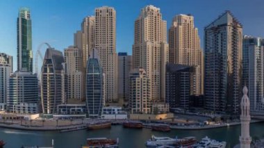 Dubai Marina körfezindeki iskeleye park etmiş lüks yatlar. Şehir havası manzaralı zaman ayarlı.