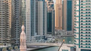 Dubai Marina körfezindeki iskeleye park etmiş lüks yatlar. Şehir havası manzaralı zaman ayarlı.