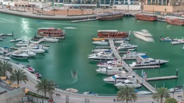 Люксовые яхты припарковались на пирсе в бухте Дубай Марина с видом на город — стоковое видео