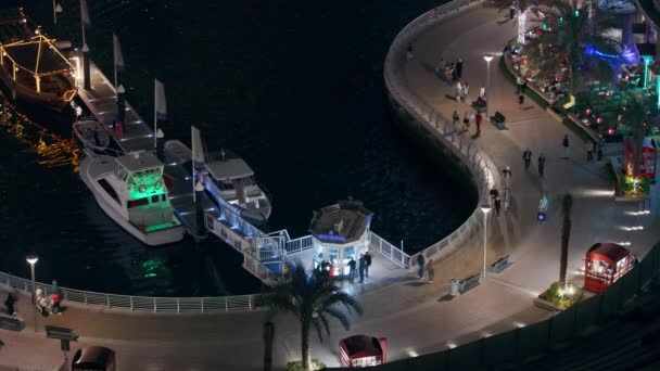 Waterfront promenade in Dubai Marina luchtfoto nachtzicht. Dubai, Verenigde Arabische Emiraten — Stockvideo