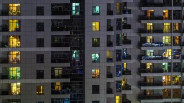 Geceleri apartmanda insanların oturduğu parlak pencereler..