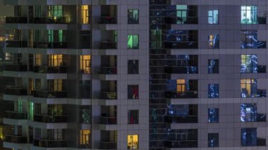 Geceleri apartmanda insanların oturduğu parlak pencereler..
