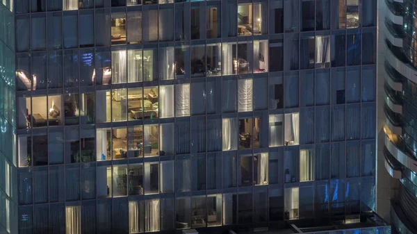 Vista notturna di timelapse appartamento esterno torre. Grattacielo a grattacielo alto con luci lampeggianti nelle finestre — Foto Stock