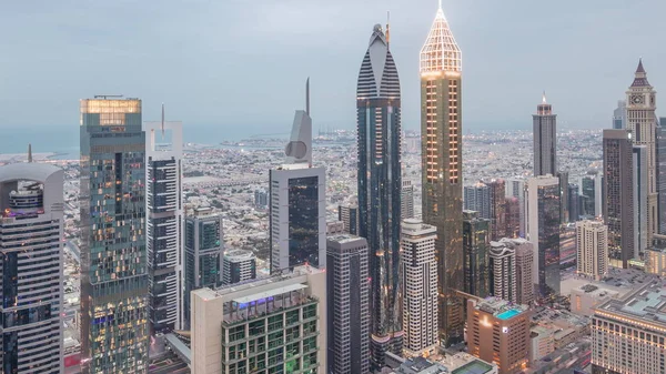 Skyline dos edifícios da Sheikh Zayed Road e DIFC dia a noite timelapse em Dubai, Emirados Árabes Unidos . — Fotografia de Stock