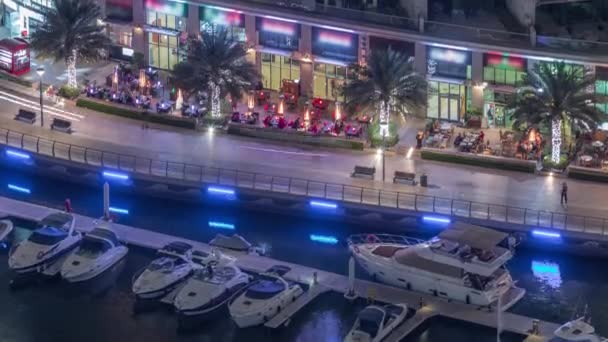 Waterfront promenade in Dubai Marina luchtfoto nachtelijke tijdspanne. Dubai, Verenigde Arabische Emiraten — Stockvideo