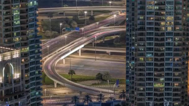 Dubai Marina salida de la carretera entre rascacielos, espagueti cruce aéreo noche timelapse — Vídeo de stock