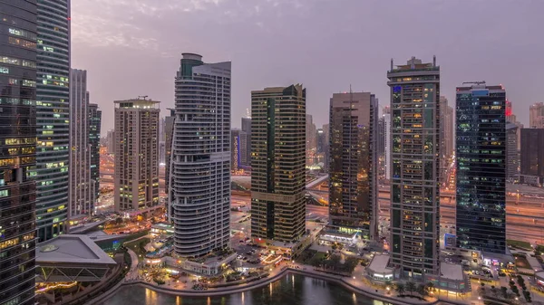 Residentiële en kantoorgebouwen in Jumeirah Lake Towers district dag tot nacht timelapse in Dubai — Stockfoto