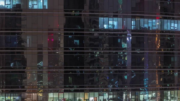 Escritório arranha-céus exterior durante o final da noite com luzes interiores acesas e pessoas que trabalham dentro da noite timelapse — Fotografia de Stock