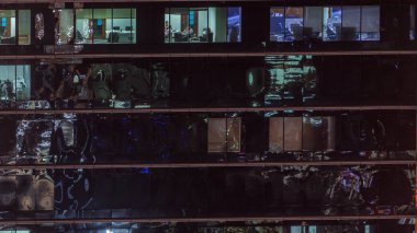 Ofis gökdelen dış gece geç saatlerde iç ışıklar ve gece timelapse içinde çalışan insanlar ile