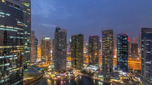 Residentiële en kantoorgebouwen in Jumeirah Lake Towers district dag tot nacht timelapse in Dubai — Stockfoto