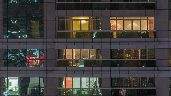 Vista nocturna del apartamento exterior timelapse edificio. Rascacielos de gran altura con luces intermitentes en las ventanas —  Fotos de Stock