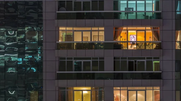 Vista nocturna del apartamento exterior timelapse edificio. Rascacielos de gran altura con luces intermitentes en las ventanas —  Fotos de Stock