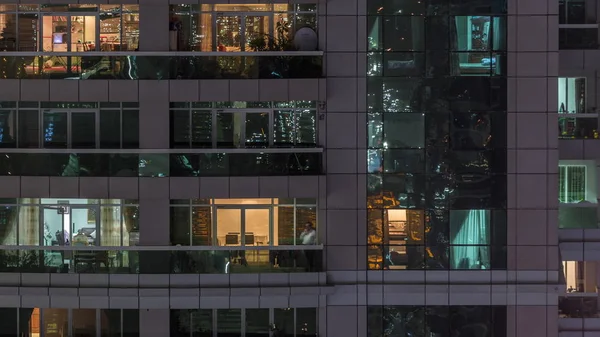 Vista nocturna del apartamento exterior timelapse edificio. Rascacielos de gran altura con luces intermitentes en las ventanas —  Fotos de Stock