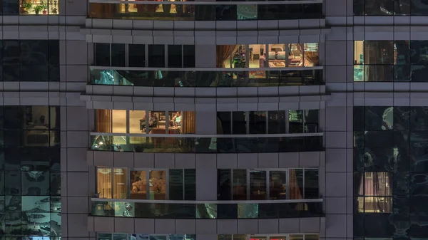 Vista nocturna del apartamento exterior timelapse edificio. Rascacielos de gran altura con luces intermitentes en las ventanas —  Fotos de Stock