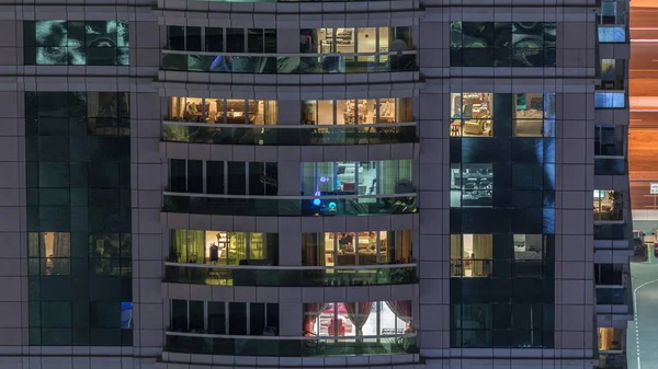 Vista nocturna del apartamento exterior timelapse edificio. Rascacielos de gran altura con luces intermitentes en las ventanas —  Fotos de Stock