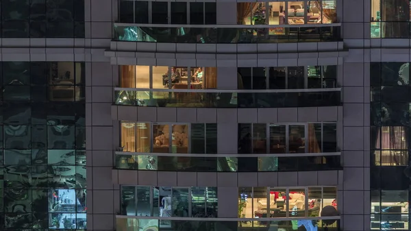 Vista nocturna del apartamento exterior timelapse edificio. Rascacielos de gran altura con luces intermitentes en las ventanas —  Fotos de Stock