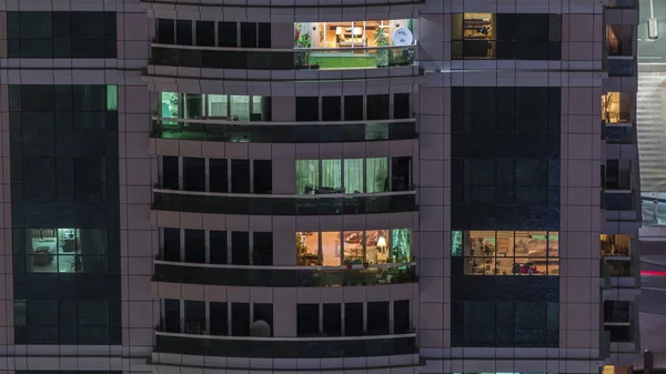 Vista nocturna del apartamento exterior timelapse edificio. Rascacielos de gran altura con luces intermitentes en las ventanas —  Fotos de Stock