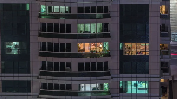 Vista nocturna del apartamento exterior timelapse edificio. Rascacielos de gran altura con luces intermitentes en las ventanas —  Fotos de Stock