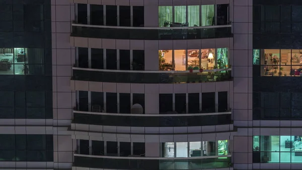 Vista notturna di appartamento esterno timelapse edificio. Grattacielo a grattacielo alto con luci lampeggianti nelle finestre — Foto Stock