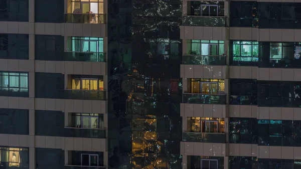 外装マンションのタイムラプスの夜景。窓に点滅するライトを備えた高層超高層ビル — ストック写真
