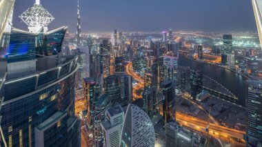Dubai'deki iş bölümü kulelerinin panoramik havadan görünümü gece gündüz.