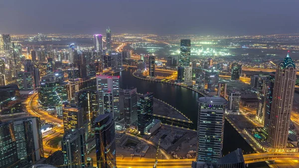 Panorama-Luftaufnahme von Business-Buchtürmen in Dubai Tag-Nacht-Zeitraffer. — Stockfoto
