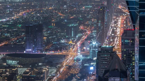 Arranha-céus na Sheikh Zayed Road e DIFC noite aérea timelapse em Dubai, Emirados Árabes Unidos . — Fotografia de Stock