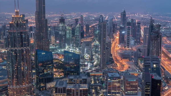 Dubai Centro skyline paisaje urbano futurista con muchos rascacielos y Burj Khalifa antena noche al día timelapse . —  Fotos de Stock