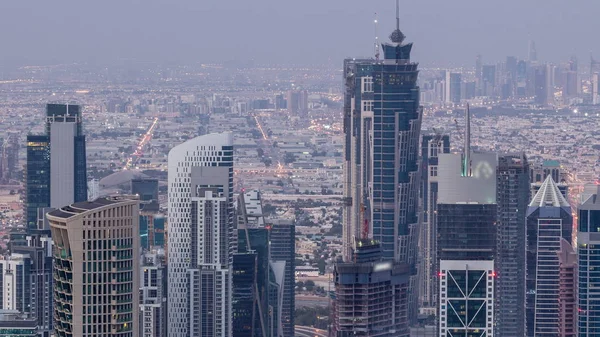 Dubai Downtown skyline futuristic cityscape with many skyscrapers and Burj Khalifa aerial night to day timelapse. — Stock Photo, Image