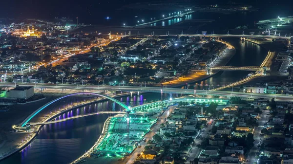 Dubai water canal with footbridge aerial night timelapse from Downtown skyscrapers rooftop