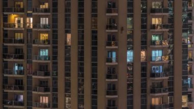 Geceleri apartmanda insanların oturduğu parlak pencereler..