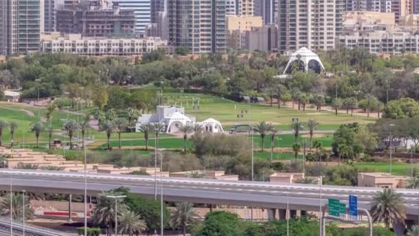 Dubai Golf Course con un paisaje urbano de Gereens y los distritos de tecom en el timelapse aéreo de fondo — Vídeo de stock
