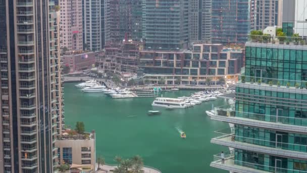 Vista aérea dos arranha-céus residenciais e de escritório da Marina do Dubai com a timelapse do dia à noite à beira-mar — Vídeo de Stock