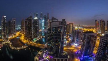 Dubai Marina konutlarının ve ofis gökdelenlerinin havadan görüntüsü. Gece gündüz deniz manzaralı.