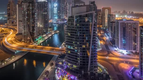 Vista aérea de los rascacielos residenciales y de oficinas de Dubai Marina con timelapse de noche al día frente al mar — Vídeo de stock