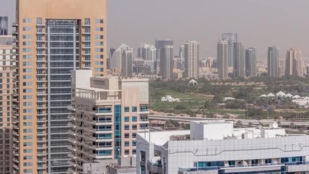 Dubai Golf Course con un paisaje urbano de Gereens y los distritos de tecom en el timelapse aéreo de fondo — Vídeos de Stock