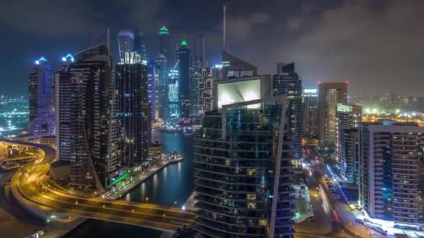 Vista aérea dos arranha-céus residenciais e de escritório da Marina do Dubai com hiperlapso da timelapse da noite à beira-mar — Vídeo de Stock