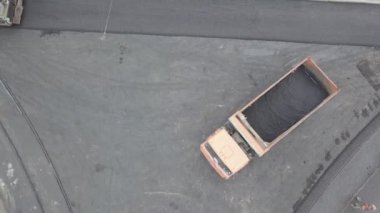 Asfalt, kaldırım yolunda makine ve titreşim silindiri yayıyor.