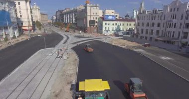 Asfalt, kaldırım yolunda makine ve titreşim silindiri yayıyor.