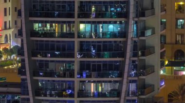 Geceleri apartmanda insanların oturduğu parlak pencereler..