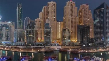 Dubai Marina körfezindeki iskeleye park etmiş lüks yatlar. Gece gündüz havadan izleniyor.