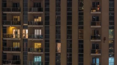 Geceleri apartmanda insanların oturduğu parlak pencereler..