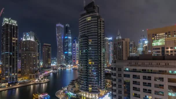 Vista aérea dos arranha-céus residenciais e de escritório da Marina do Dubai com a timelapse da noite à beira-mar — Vídeo de Stock