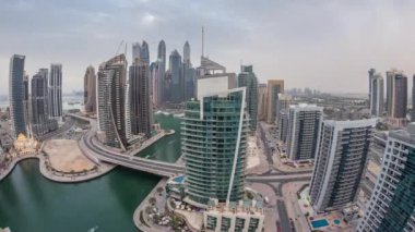 Dubai Marina yerleşim yerlerinin ve ofis gökdelenlerinin havadan görüntüsü. Rıhtıma bakan gündüz ve gece saatleri var.