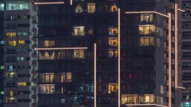 Geceleri apartmanda insanların oturduğu parlak pencereler..