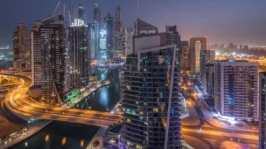 Dubai Marina konutlarının ve ofis gökdelenlerinin havadan görüntüsü. Gece gündüz deniz manzaralı.