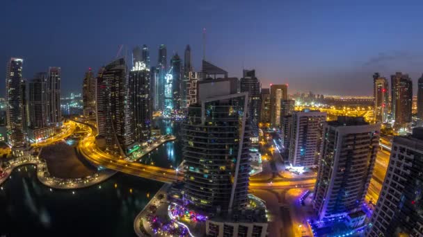 Vista aérea de los rascacielos residenciales y de oficinas de Dubai Marina con timelapse de noche al día frente al mar — Vídeo de stock